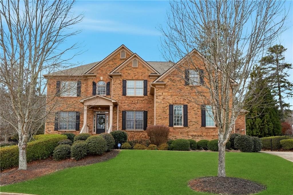 Two Story Traditional Red Brick Estate with Black Shutters and Professional Landscaping.jpg